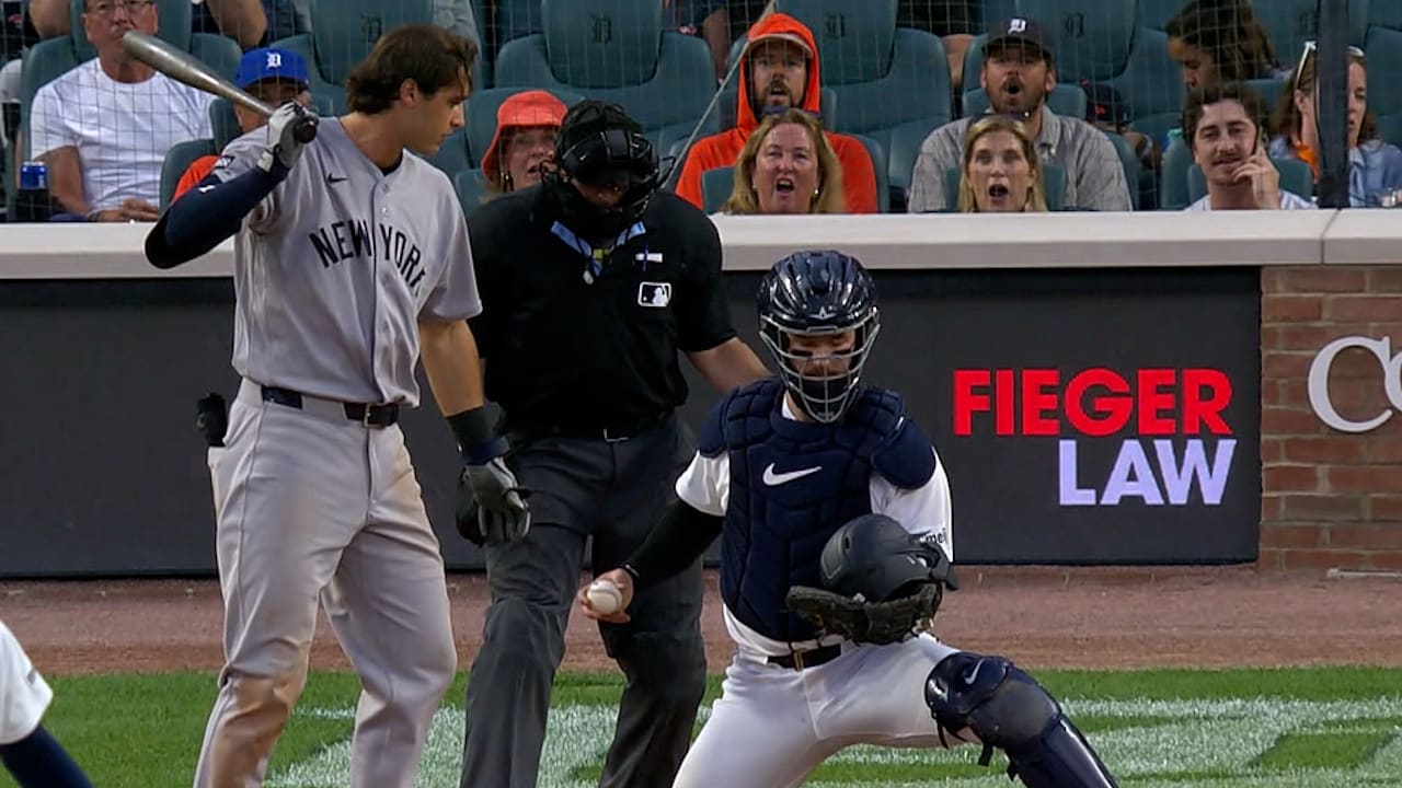 Yankees batter Spencer Jones looks down at his helmet in the mitt of Tigers catcher Dillon Dingler
