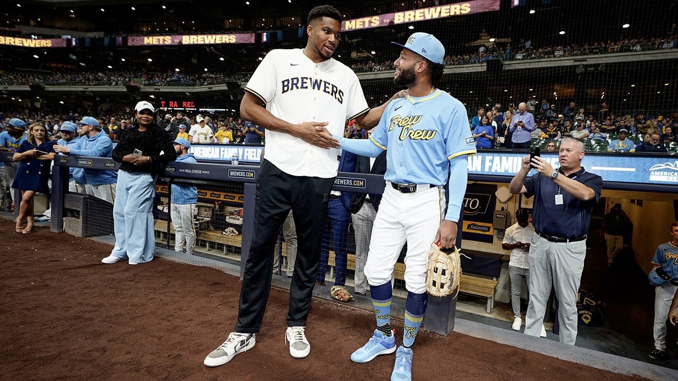 The Milwaukee Bucks' Giannis Antetokounmpo greets Brewers rookie Jackson Chourio before the game