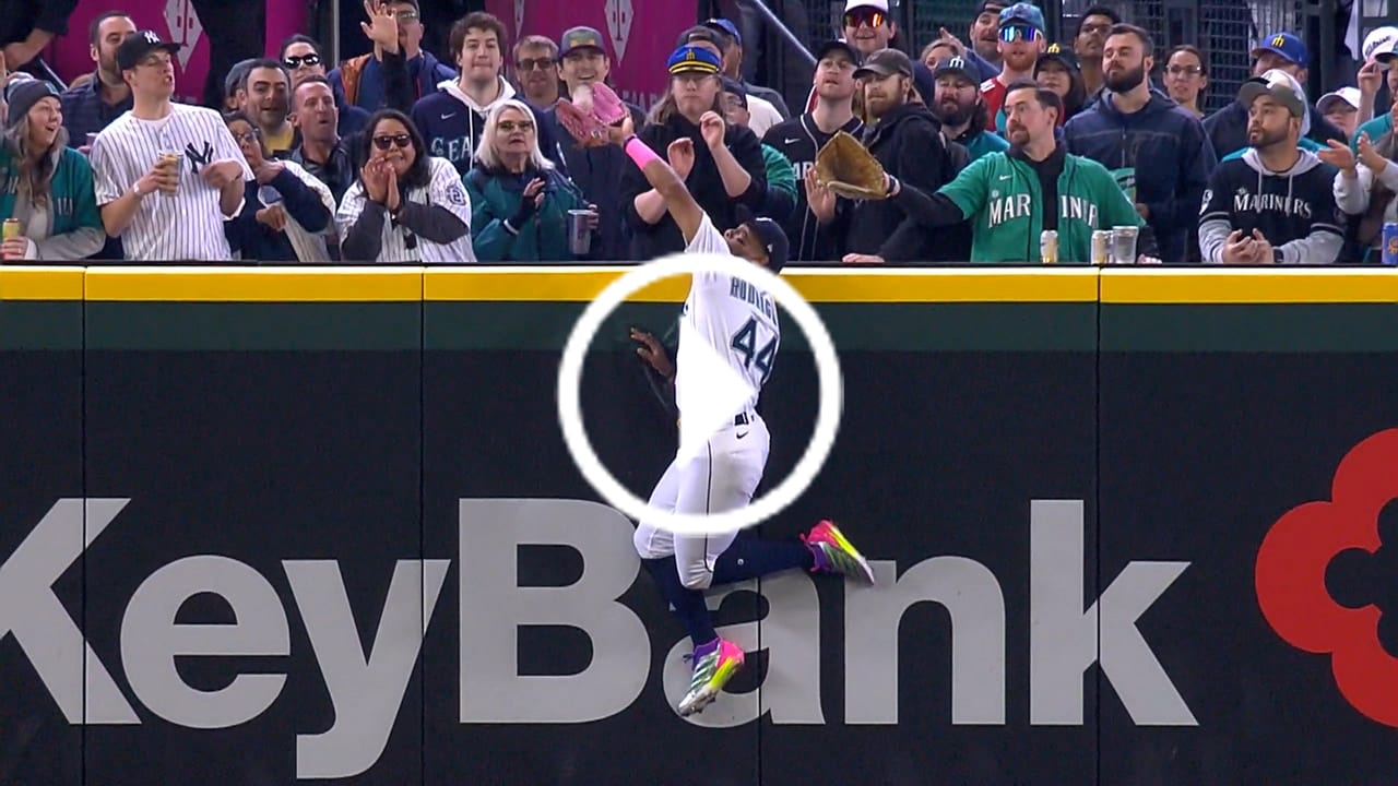 A play button over a screengrab of Julio Rodríguez leaping at the wall as the ball lands in his glove