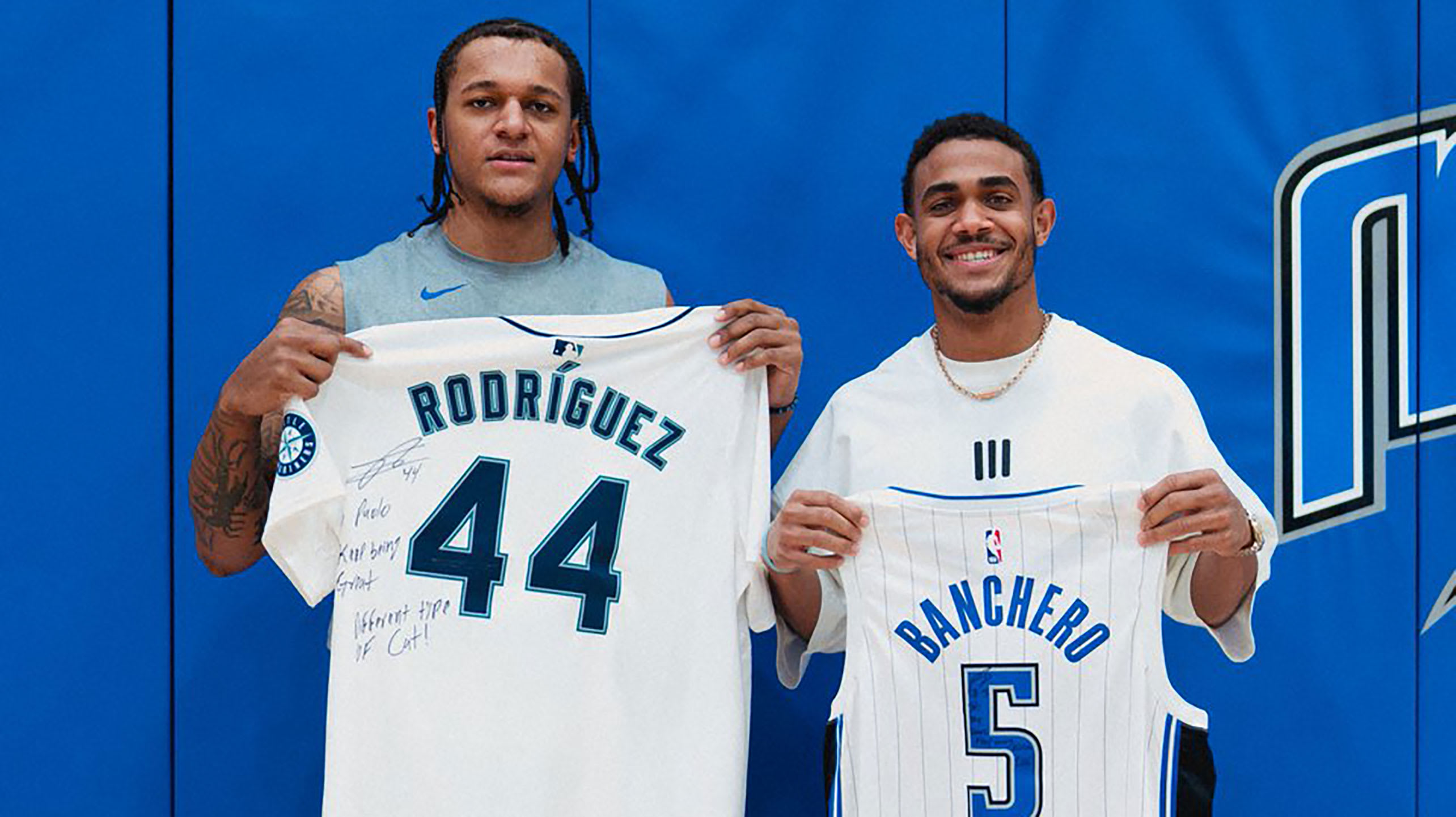 Julio Rodríguez and Paolo Banchero hold up each other's jerseys