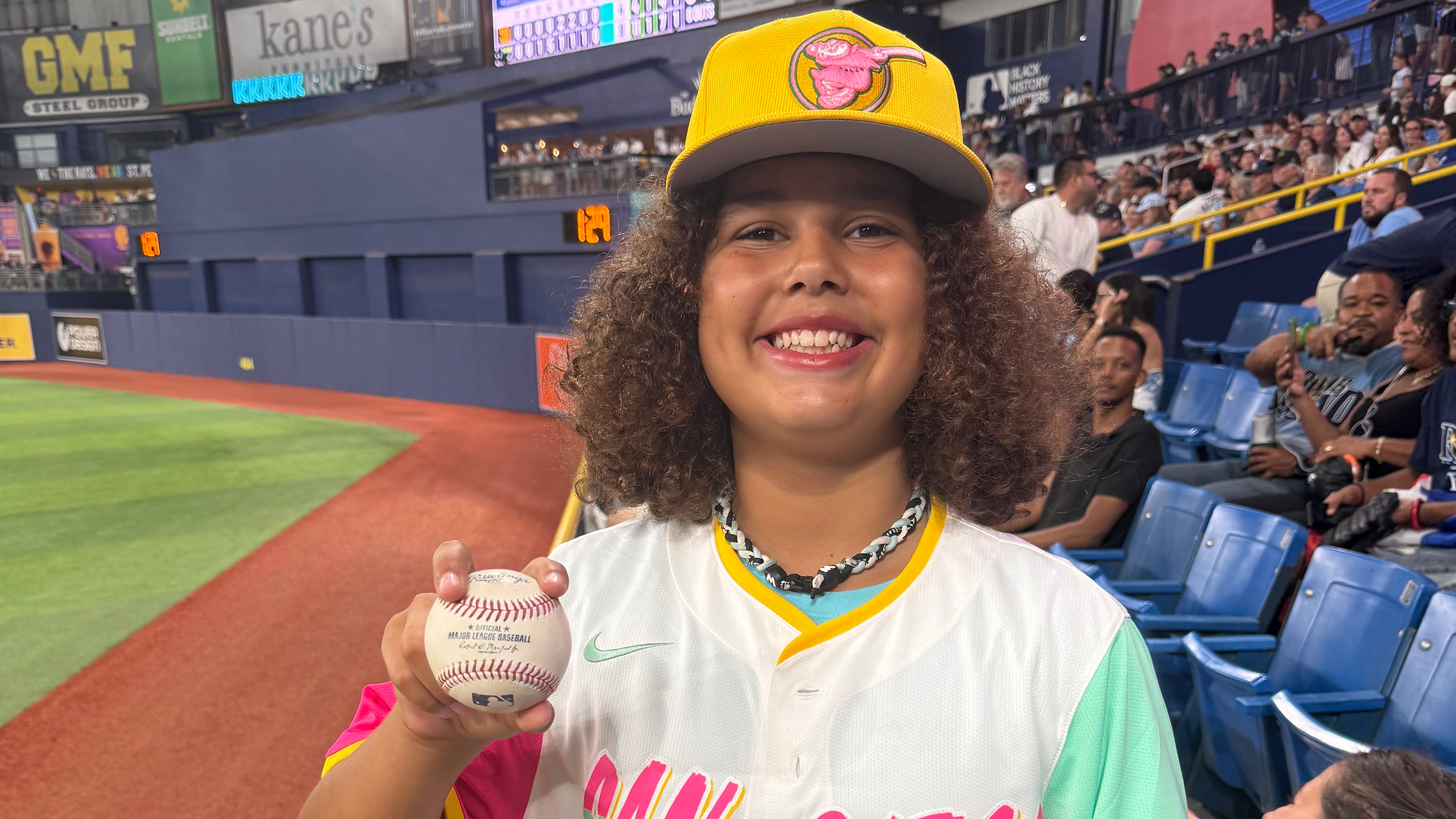 12-year-old Padres fan Fynn Szostak holds up a home run ball