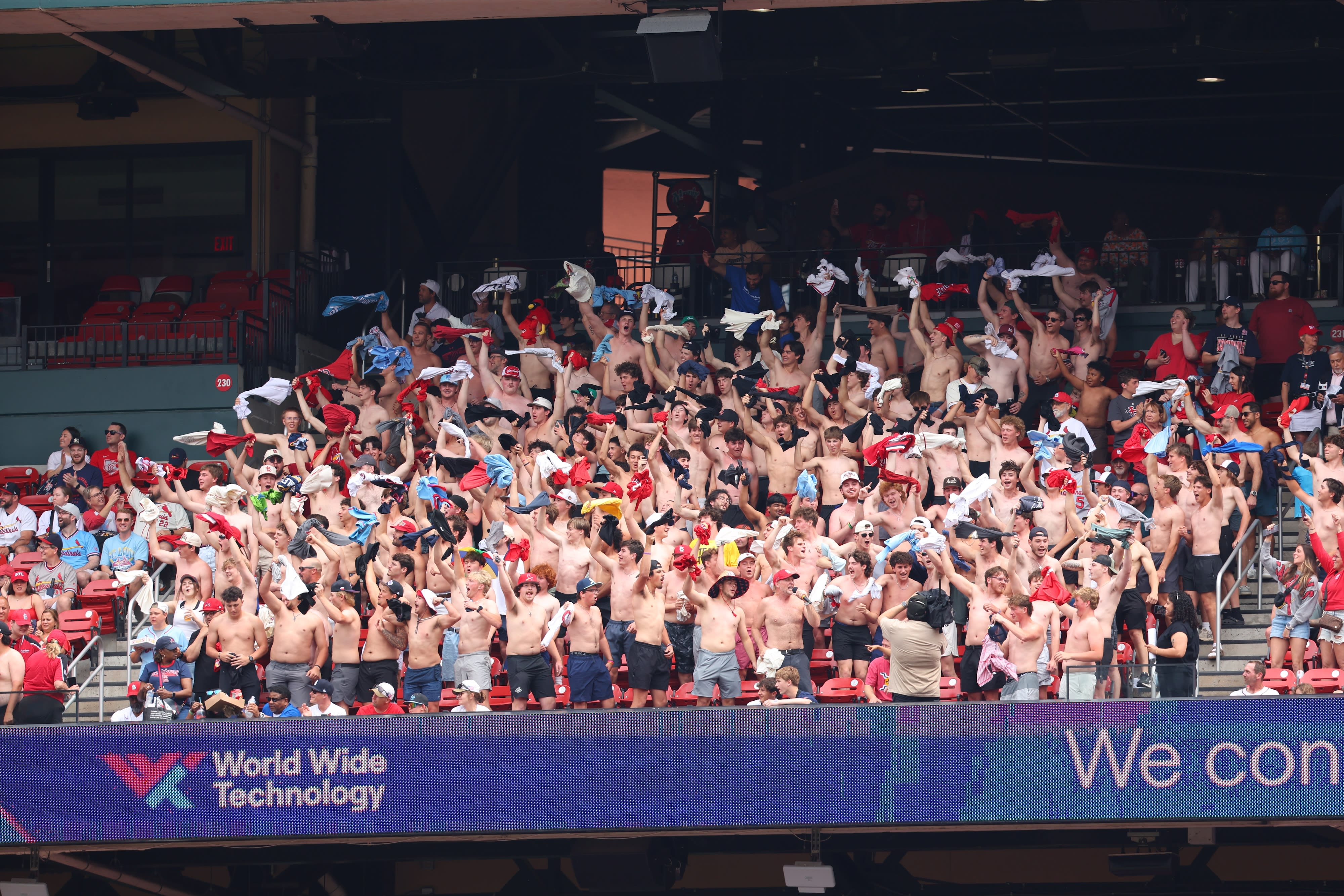 Fans wave their shirts over their heads at a Cardinals game