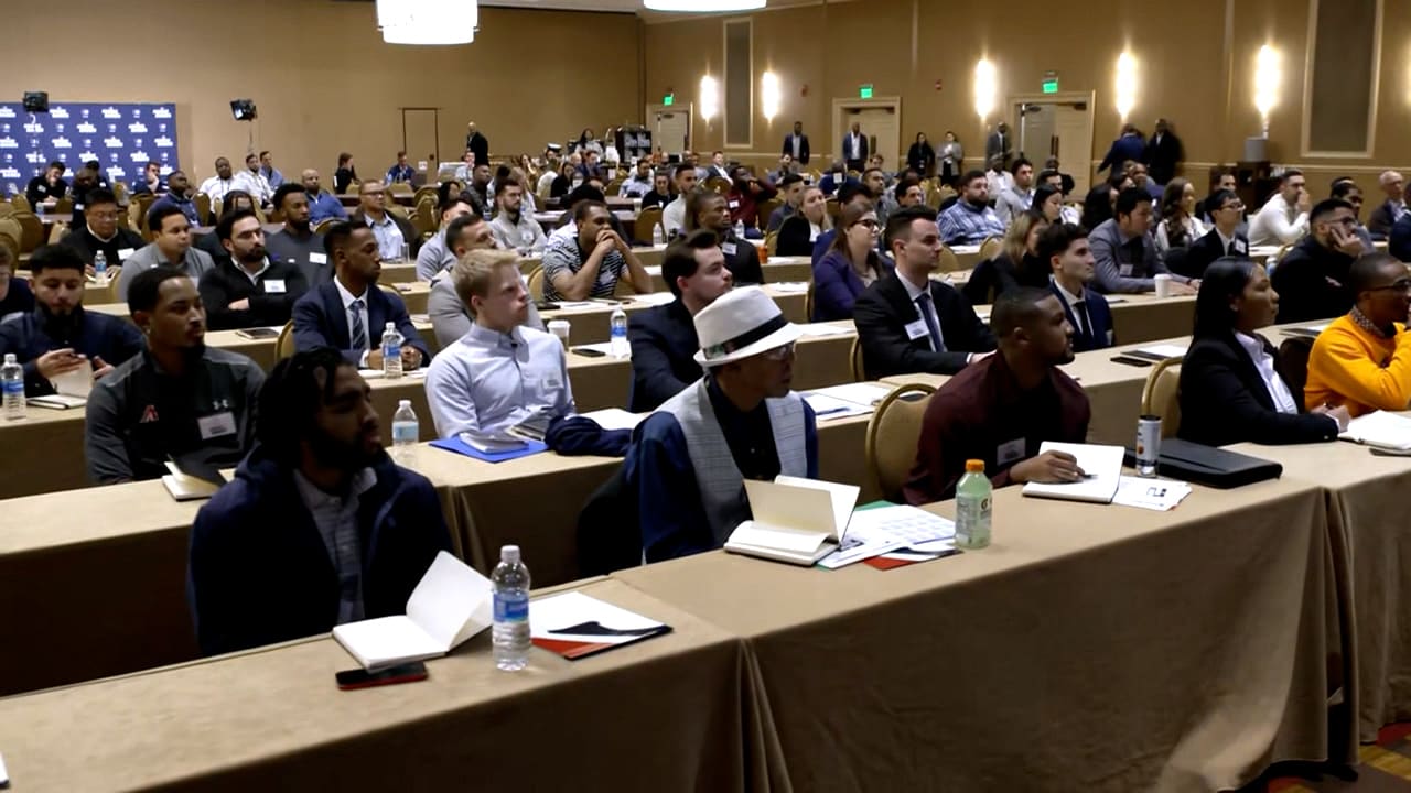 Dozens of people at tables in a conference room