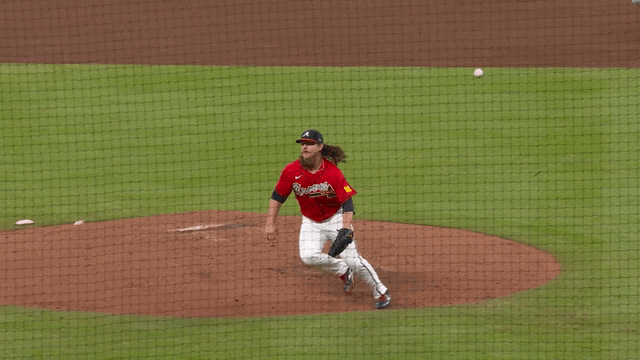 An animated gif of Grant Holmes bobbling a ball but recovering to make the out at first