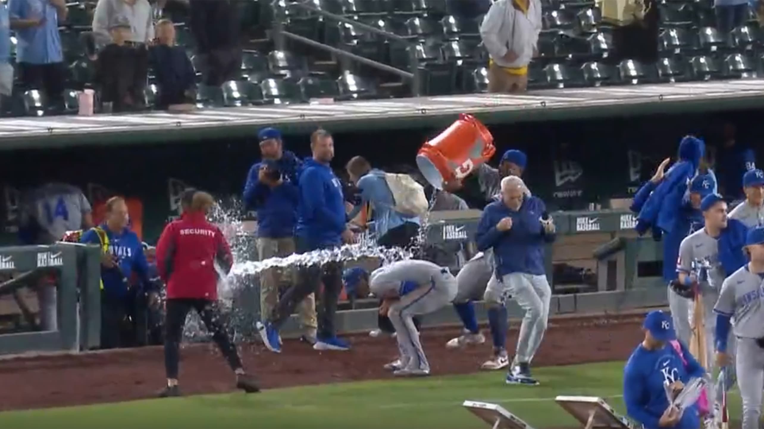 A security guard is soaked when Salvador Perez tries to douse Bobby Witt Jr.