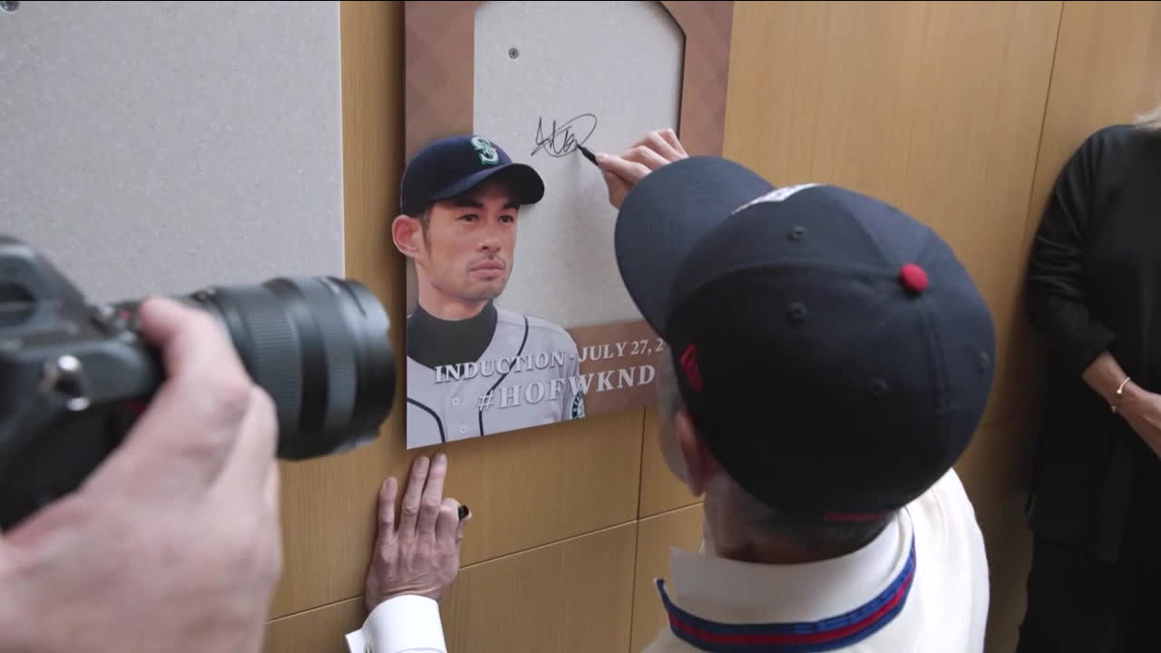 Ichiro Suzuki signs the space where his Hall of Fame plaque will hang