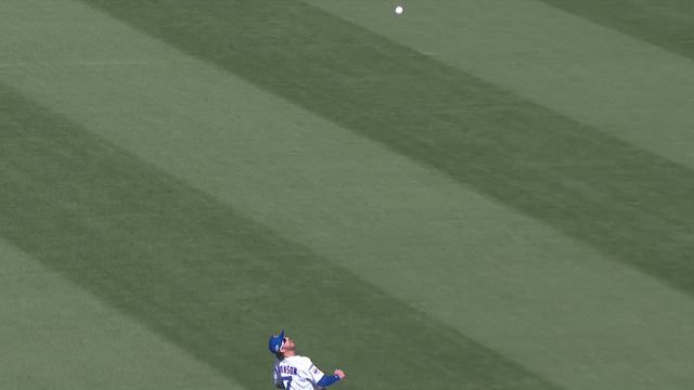 An animated gif of Dansby Swanson making a twisting, over-the-shoulder catch on the outfield grass