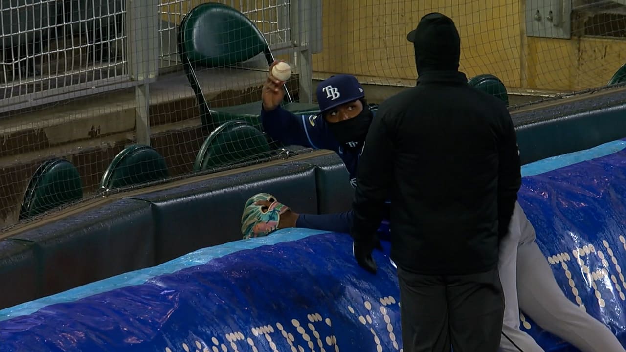 Junior Caminero shows a baseball to an umpire