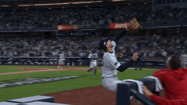 An animated gif of Ryan McMahon making a catch and flipping into the Red Sox dugout