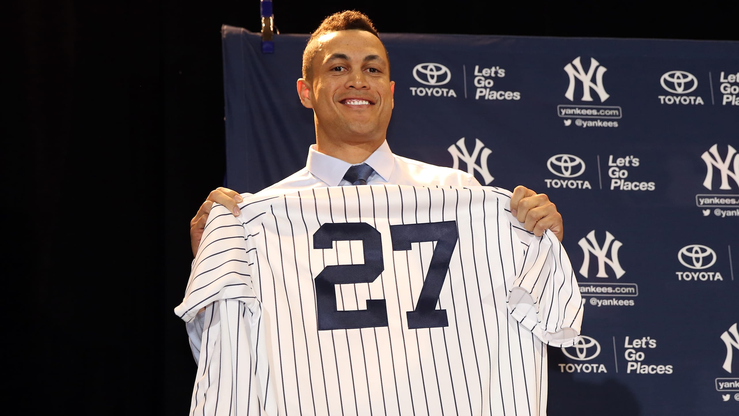 Giancarlo Stanton holds up a Yankees jersey