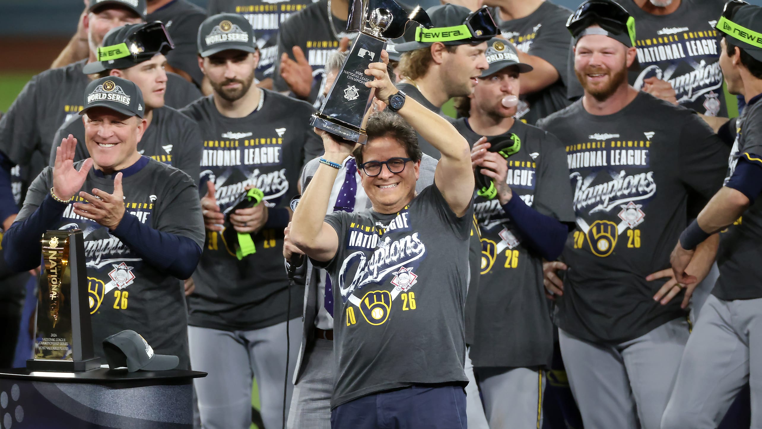 Brewers owner Mark Attanasio holds up the NL championship trophy after the NLCS clincher