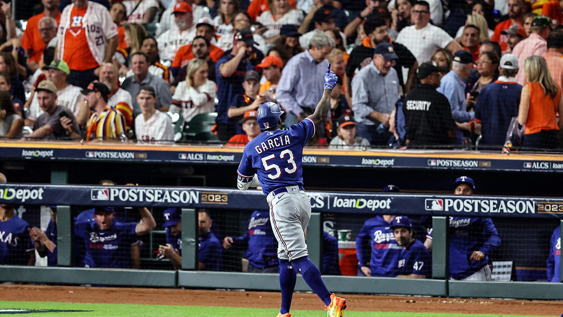 Adolis García raises his right arm as he rounds the bases after his grand slam