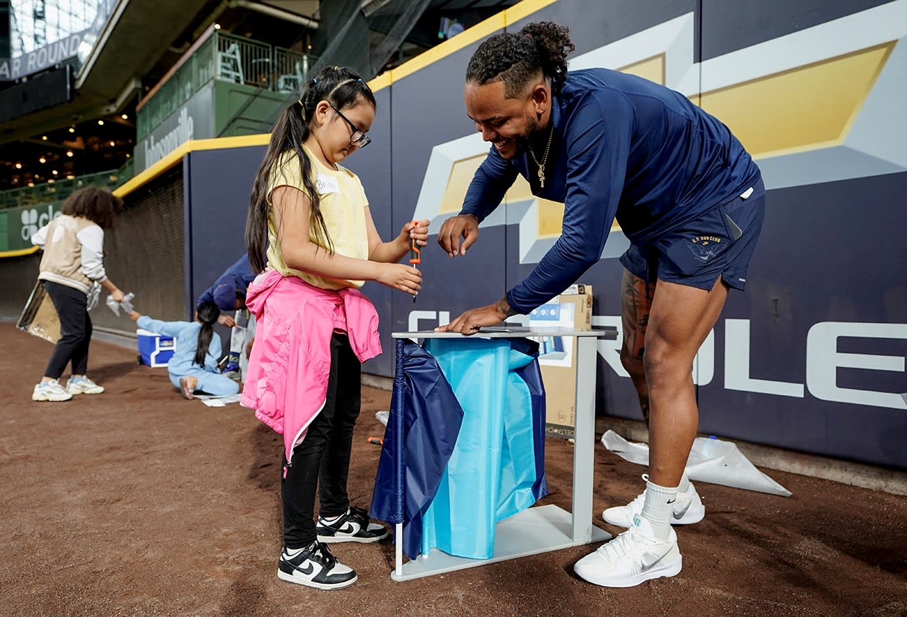 Freddy Peralta smiling as he helps construct a bookshelf (Photo: Milwaukee Brewers)