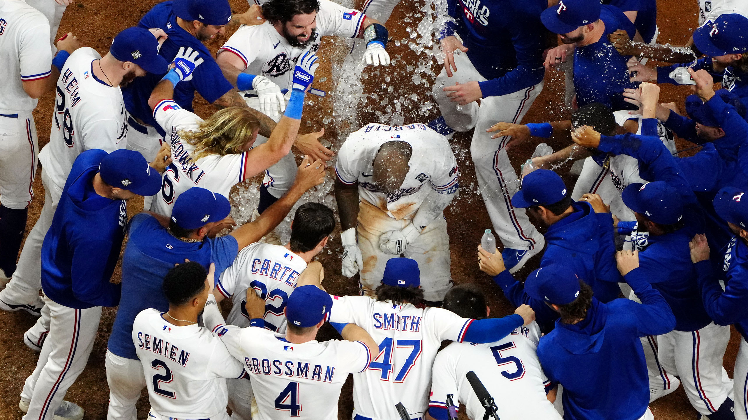 A view from above as Adolis García touches home plate amid a mob of Texas Rangers