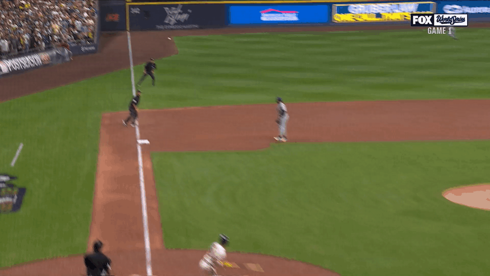 An animated gif of a hit landing just on the left-field line next to the umpire, who signals it fair