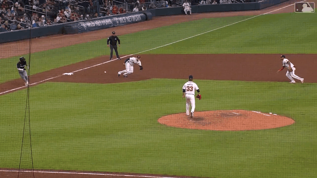 Austin Riley spins on his knees and throws a strike to the plate to get the out