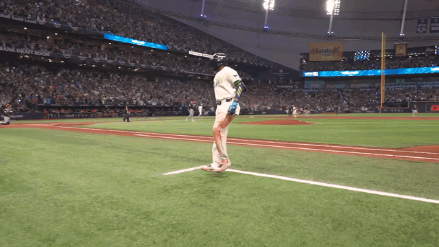 An animated gif of Junior Caminero stopping before first base to pound his chest during his home run trot