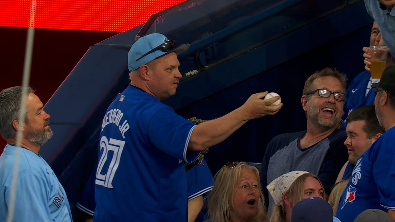 A fan hands over a foul ball 