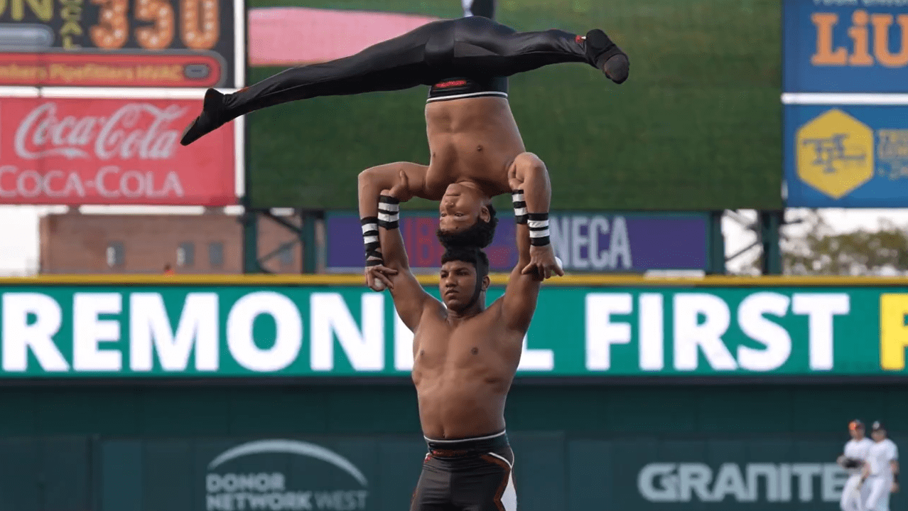 One acrobat balances on his head on the head of another
