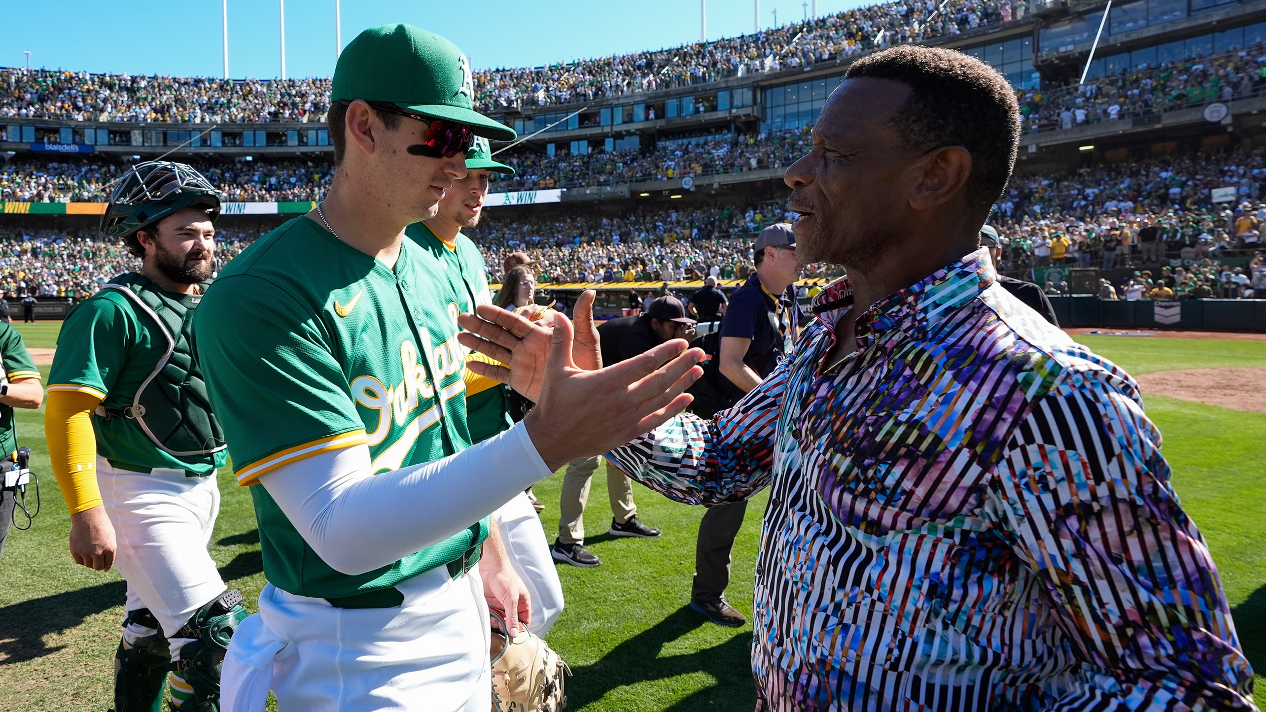 Rickey Henderson greets A's players after a game