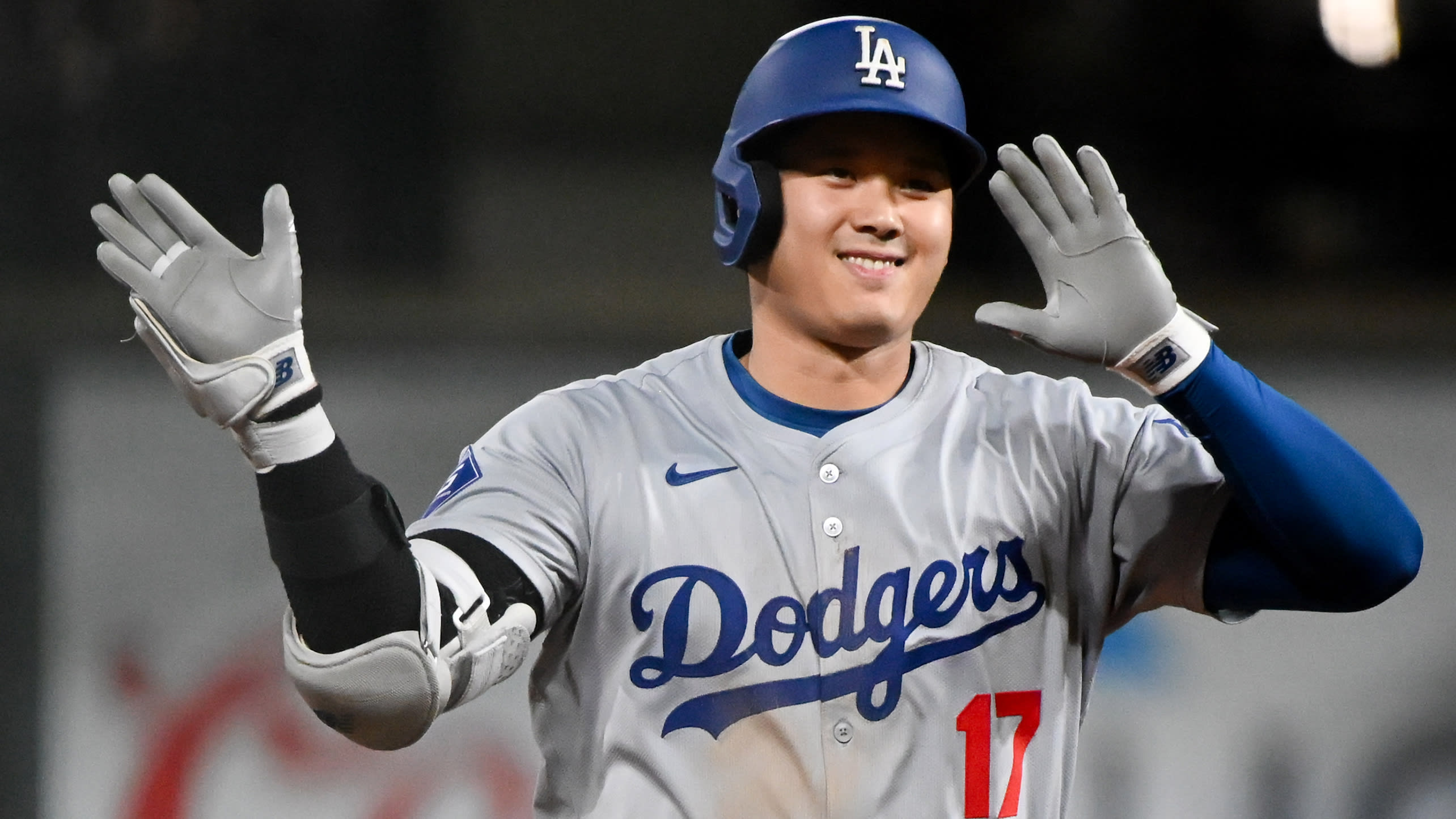 Shohei Ohtani smiles and waves as he rounds the bases on a home run