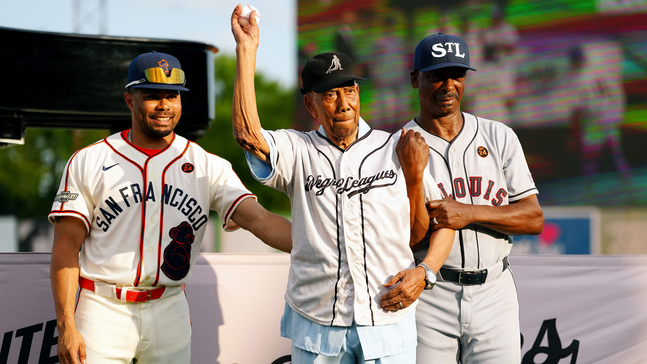 Bill Greason throws out a first pitch alongside representatives for the Giants and Cardinals