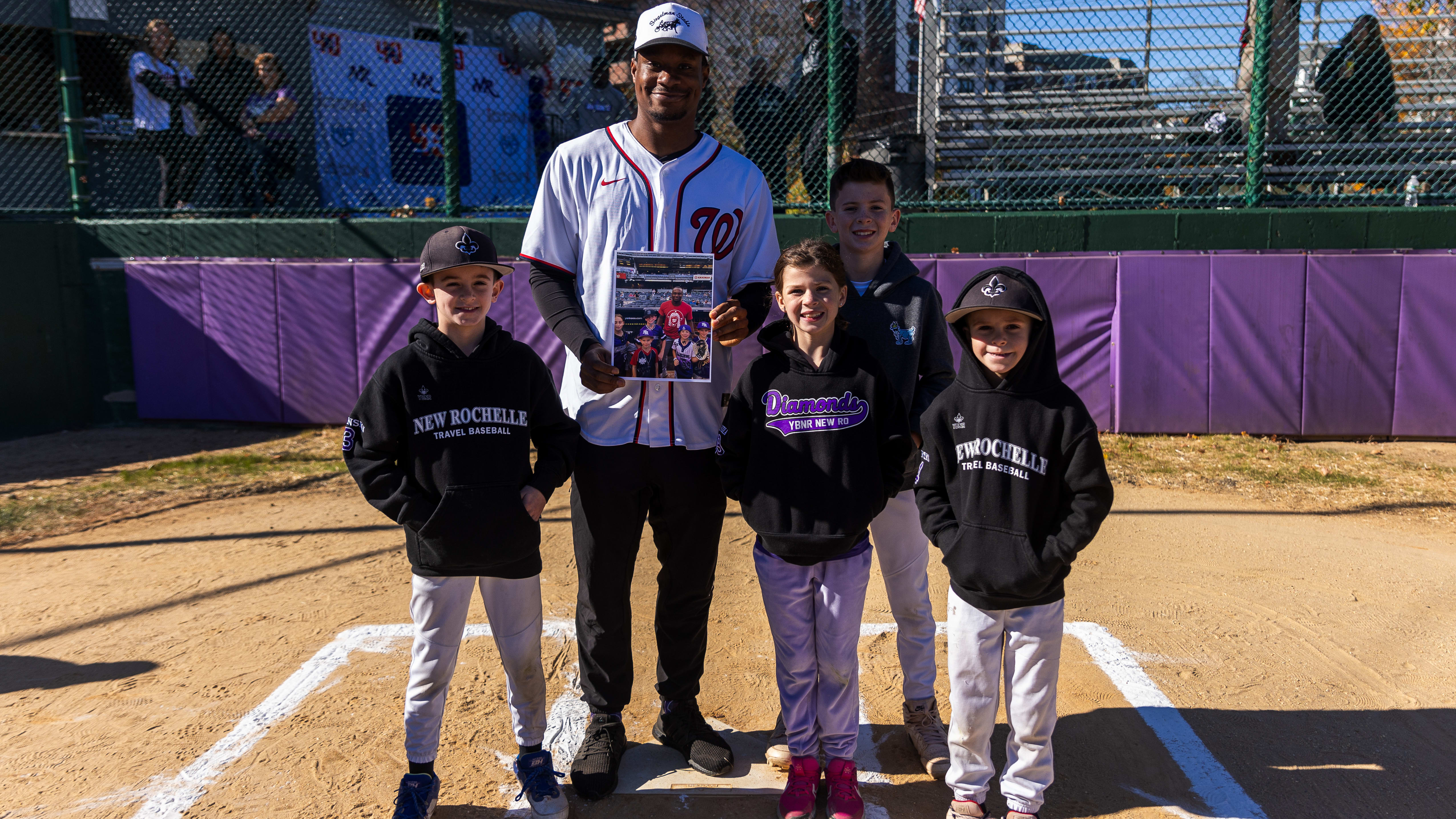 Josiah Gray poses for a picture with four kids