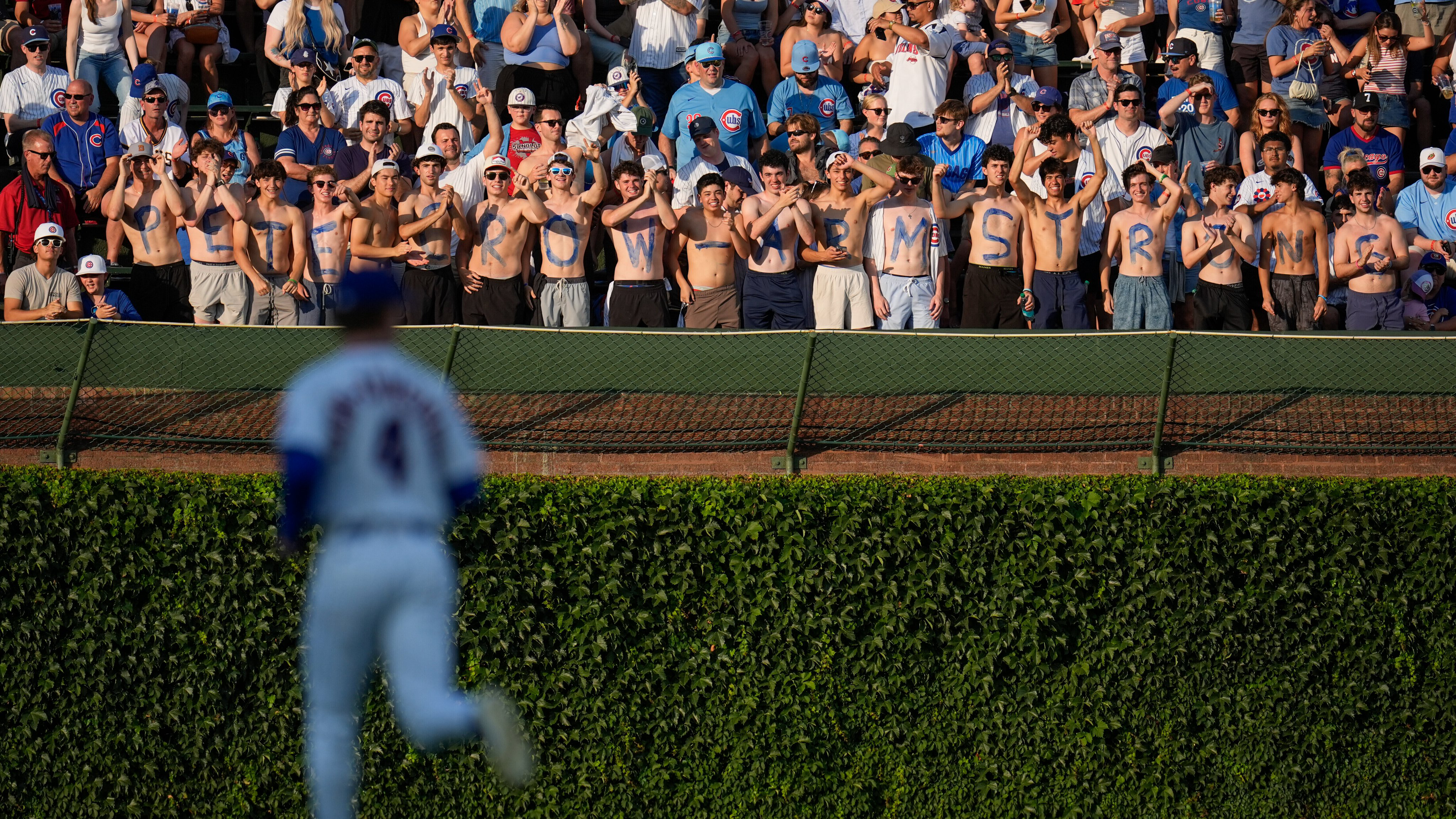 Fans in the Wrigley Field bleachers with Pete Crow-Armstrong's name spelled out on their chests