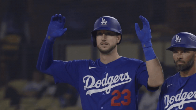 An animated gif of Kyle Tucker tentatively waving his arms above his head and smiling