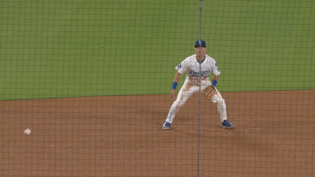 An animated gif of Tommy Edman making a leaping catch and Dustin May shouting in appreciation