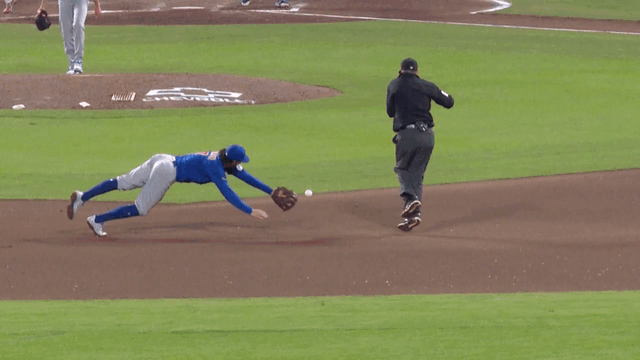 An animated gif of Dansby Swanson making a diving stop and throw to first from the seat of his pants