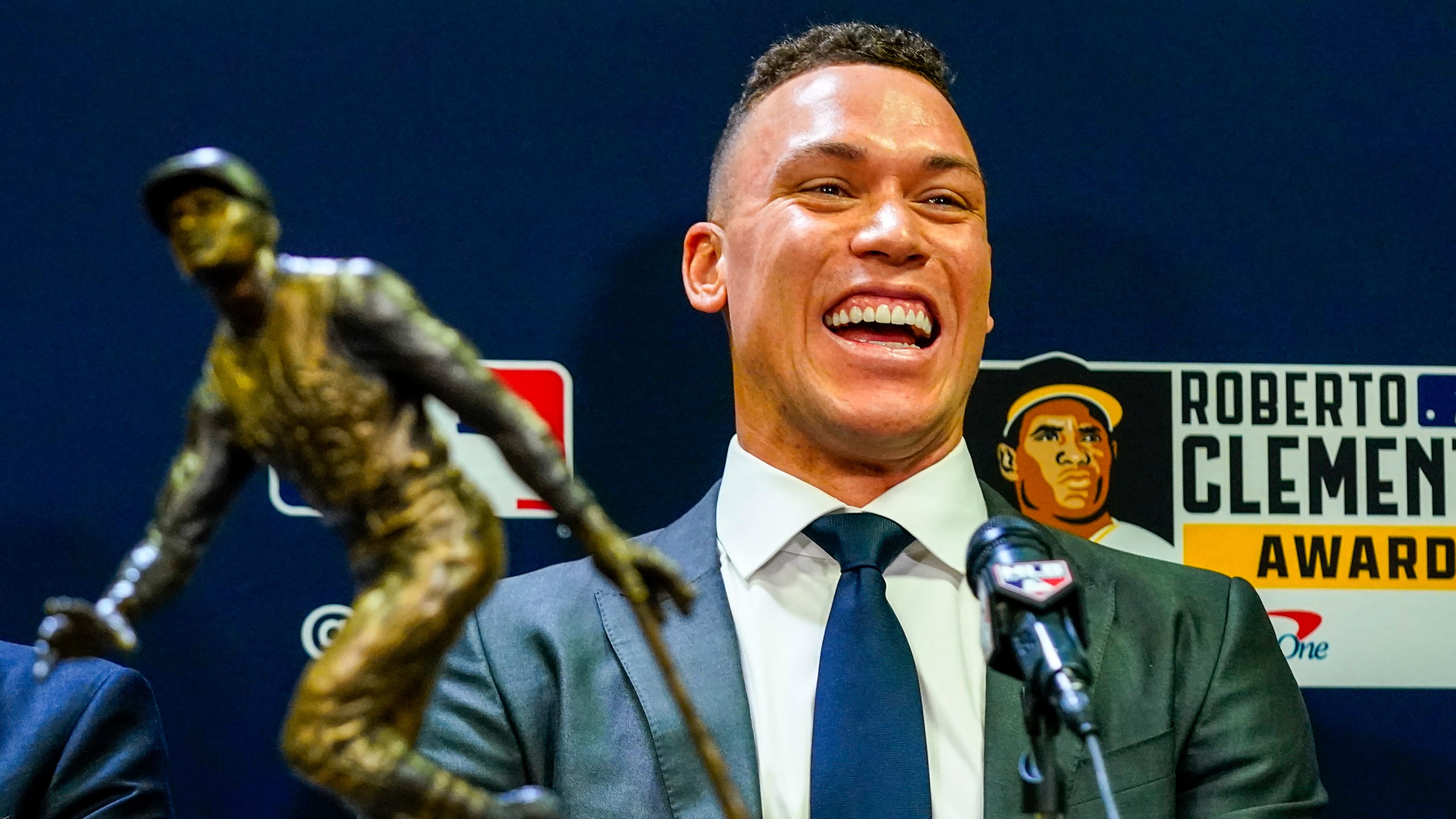 Aaron Judge laughs with the Roberto Clemente Award trophy in the foreground