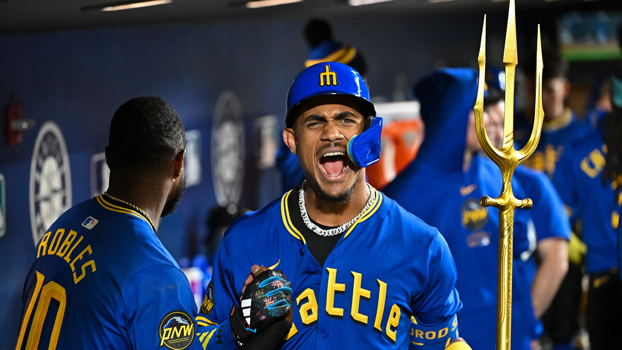 Julio Rodríguez celebrates his go-ahead homer with the trident in the dugout