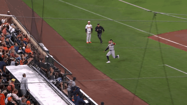 An animated gif of Carlos Correa making a sliding catch on the warning track in foul territory