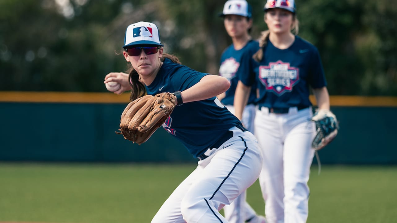 A girl fields a baseball during fielding drills