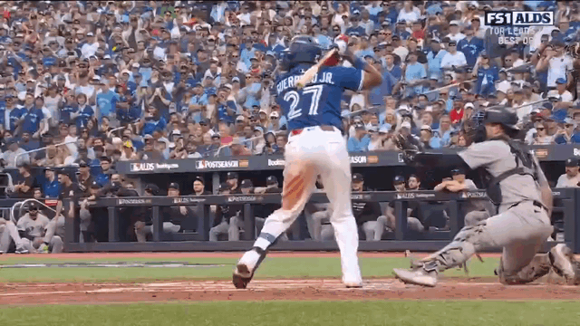 An animated gif of Vladimir Guerrero Jr. hitting a grand slam and tossing his bat