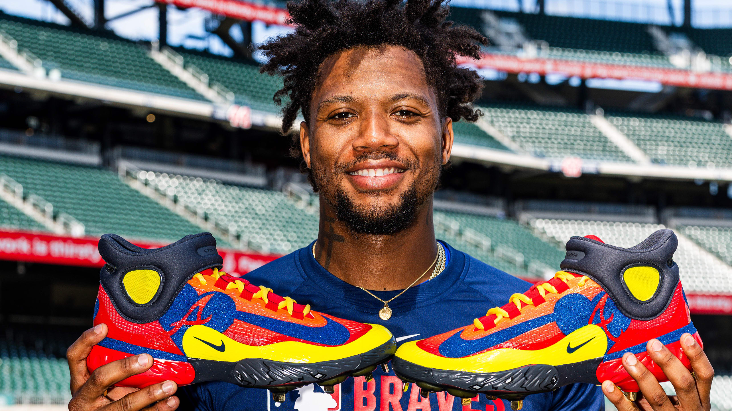 Ronald Acuña Jr. holds up a pair of custom cleats