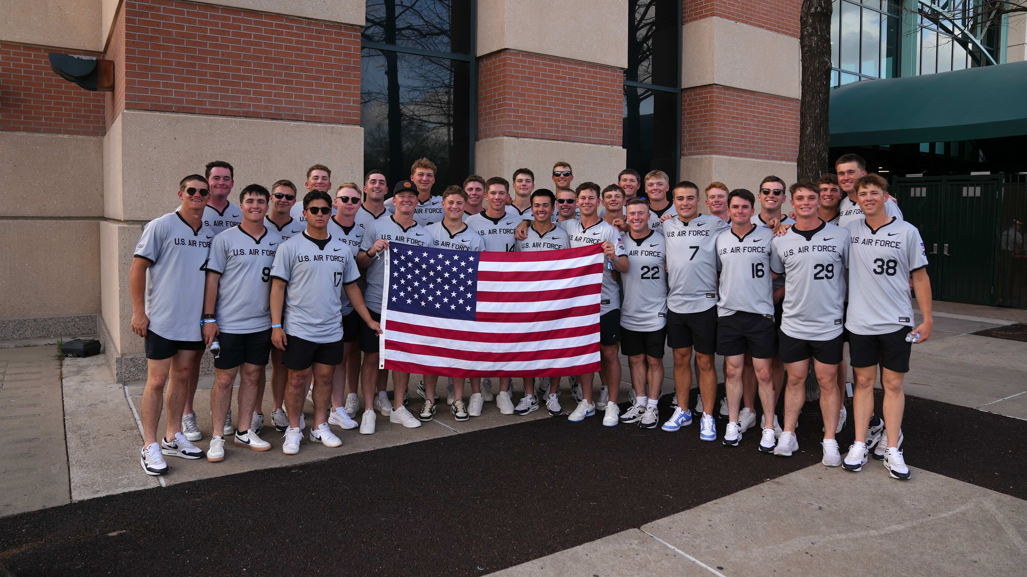 The Air Force baseball team holds an American flag