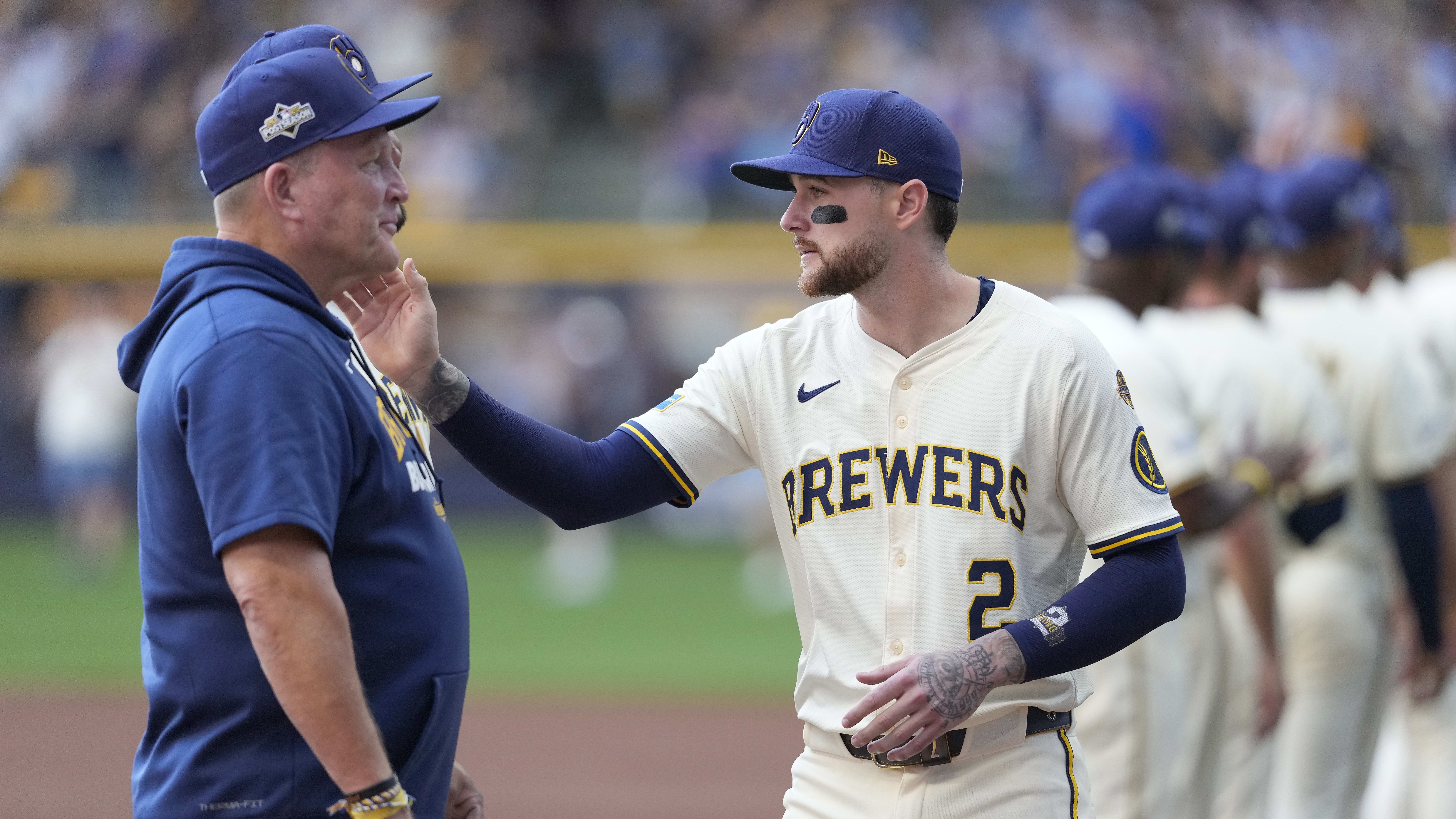 Pat Murphy stands expressionless on the pregame handshake line