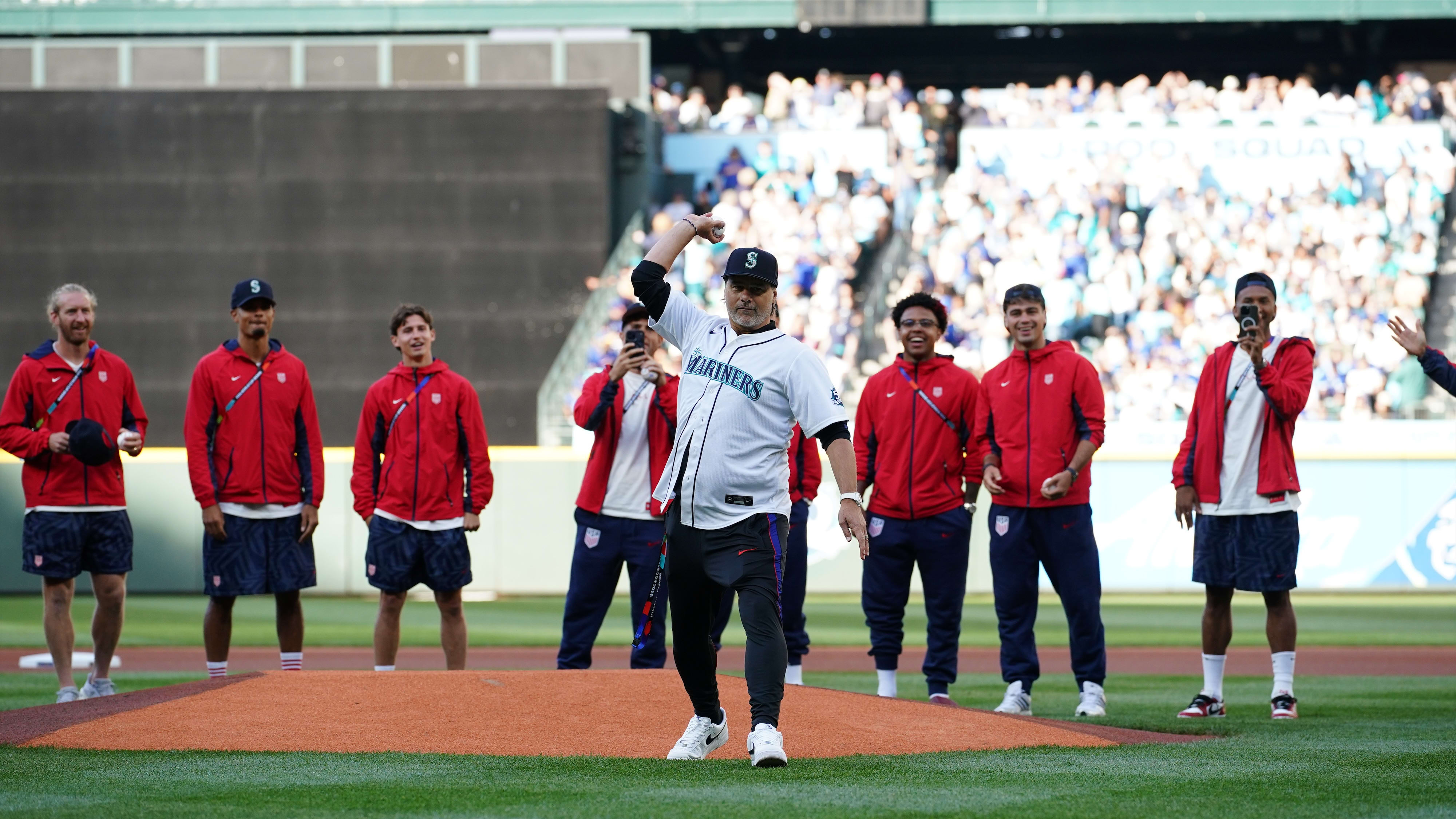 U.S. men's soccer coach Mauricio Pochettino throws out a first pitch with the team behind him