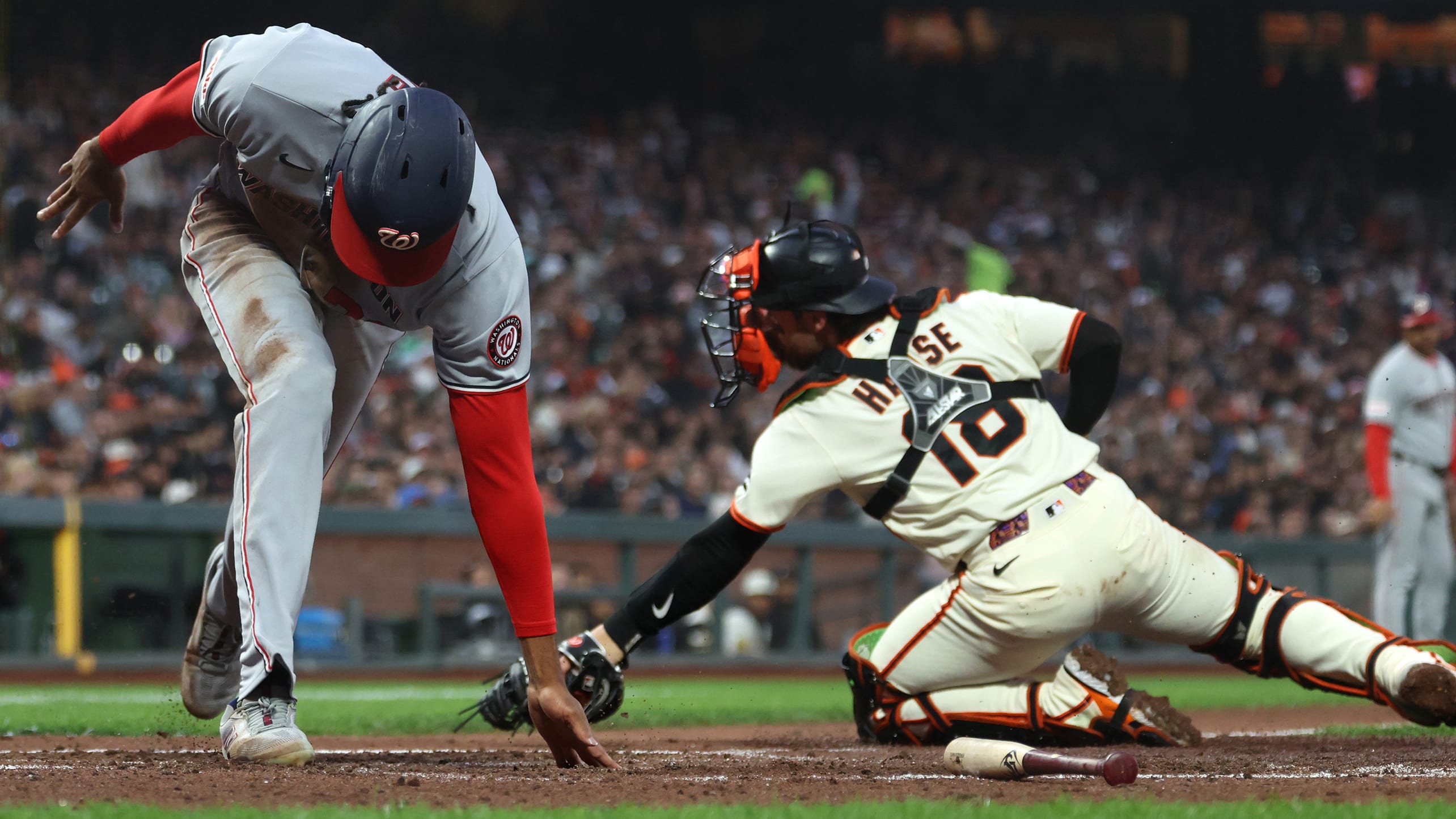 James Wood reaches down to touch home plate with his hand