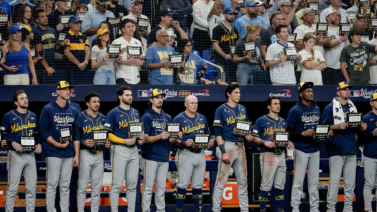 The Brewers stand in front of their dugout during the Stand Up To Cancer moment