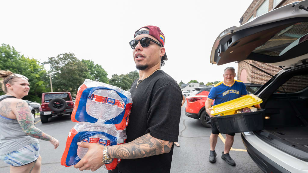 William Contreras helps pack non-perishable items and water to be shipped to Venezuela. (Kirsten Schmitt/Brewers)
