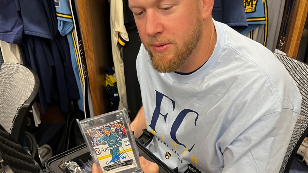 Jared Koenig shows off his signed Macklin Celebrini card. (Adam McCalvy/MLB.com)