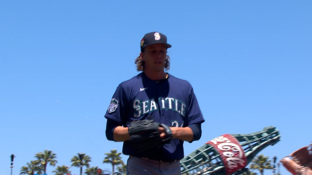 Seattle Mariners' Mike Ford walks through the dugout with a