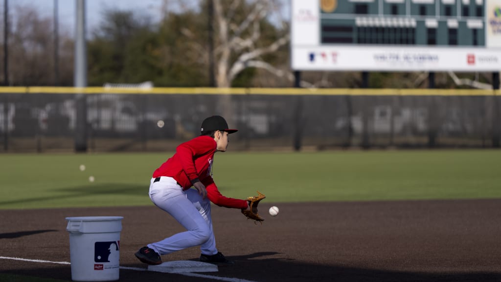 A boy at third base catches the ball at the Texas Rangers Youth Academy.