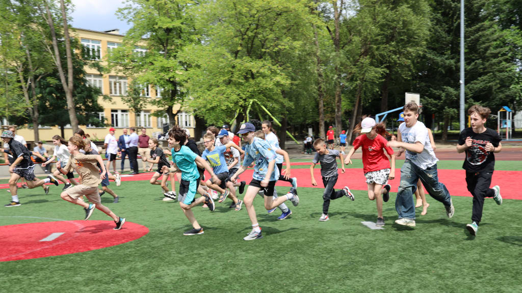 A group of children run during a recent baseball camp hosted by New York Empire Baseball in Poland.