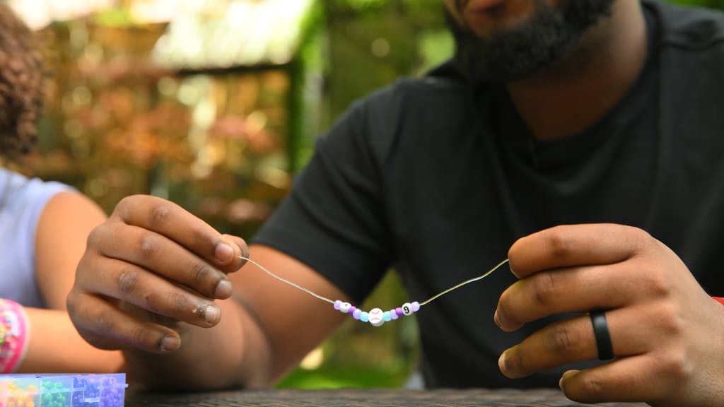 Vladimir Guerrero Jr. holds out the friendship bracelet he's making for his daughter, Vlaimel.