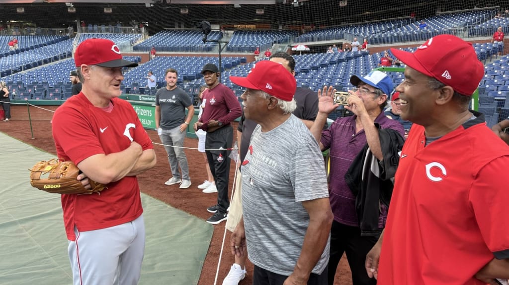 "Big Chuck" (center) and "Little Chuck" (right) speak to Reds manager David Bell before the game.