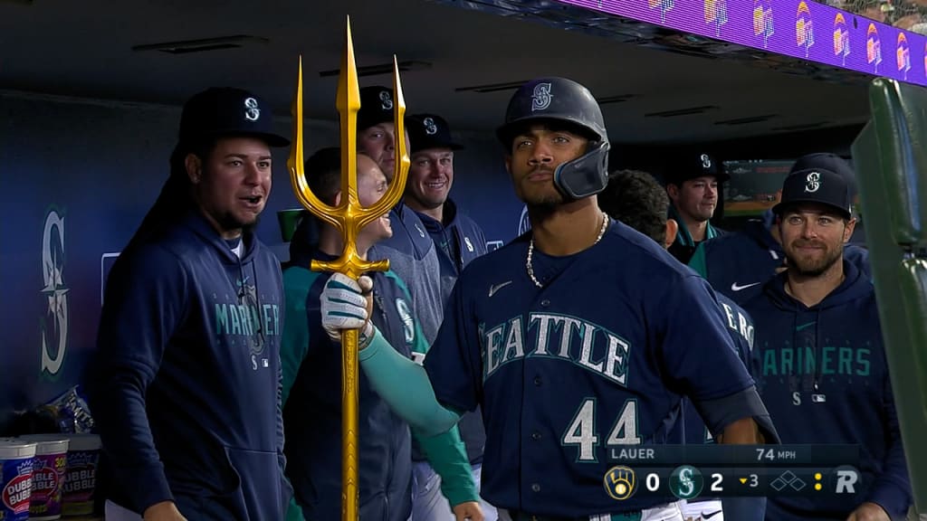 Seattle Mariners' Eugenio Suarez, left, holds a trident in the